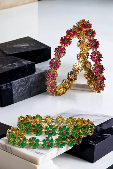 Detailed view of Arika floral bangles in ruby and emerald tones. Gold-plated jewelry set for traditional and festive occasions.