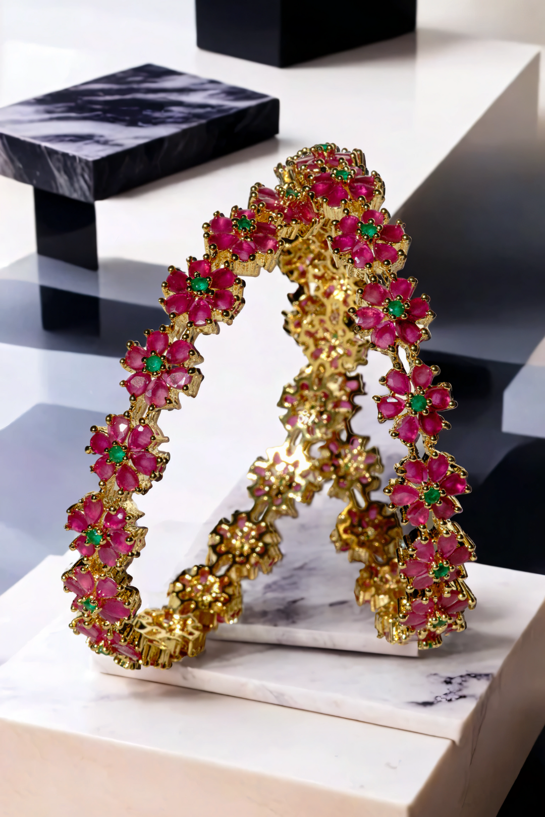 Ruby-accented floral bangles from the Arika gold-plated 7-piece set. Elegant accessory for ethnic and bridal wear collections.