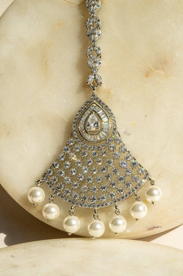 Rhodium-plated maang tikka with white American Diamonds and pearl drop accents from Inaury
