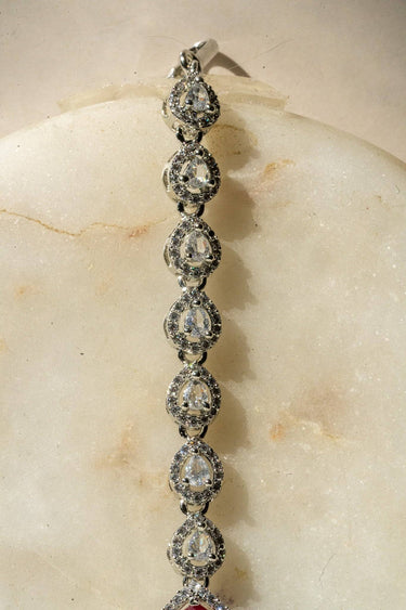 Rhodium-plated maang tikka with matte green teardrop center and white AD stones from Inaury