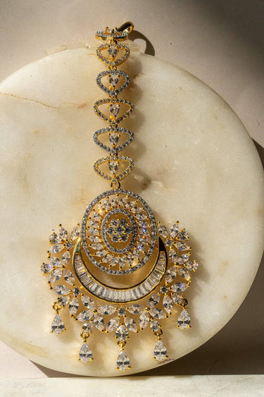 Iliyana Maang Tikka in rhodium finish with CZ stones, featuring a floral crescent design. Ideal for bridal and festive hair styling by Inaury.