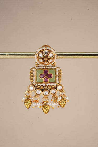 A close up studio catalog shot focusing on a single Aadhya Kundan drop earring hanging on a display bar to highlight the fine seed pearl trim.