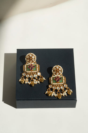 An alternative angled presentation layout showing the foil backed glass polki stones of the Aadhya earrings resting on top of a jewelry box.