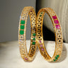 A clean vertical studio product display of the pair of gold plated Kyra traditional festive bangles showcasing the color blocked gemstone layout.
