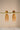 A clean studio view of the reverse side of the Lara gold jhumka earrings on a display bar showing the push back closure and finish quality.