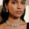 A lifestyle studio portrait of a model wearing the rhodium-plated Shanaya geometric choker set paired with an elegant black saree.