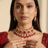 A closer neckline view on a model showing the collarbone contouring drape of the Sweta antique gold-plated red choker set.