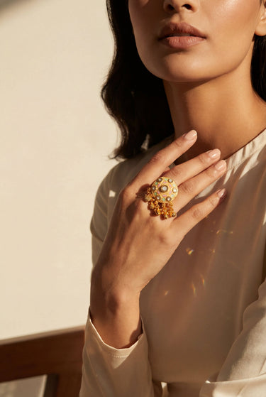 South Asian woman wearing Tara gold meenakari charm ring with pastel enamel dome and ghungroo charms Inaury desi jewelry