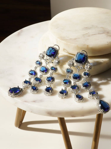 Jennie AD Chandelier Earrings in rhodium-plated silver, available in six colors: silver & emerald green, silver & turquoise, silver & sapphire blue, silver & maroon, silver & purple, silver & black, featuring asymmetrical design and AD stones.