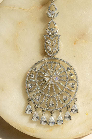 Round-shaped maang tikka with teardrop AD stones in rhodium plating with white accents from Inaury