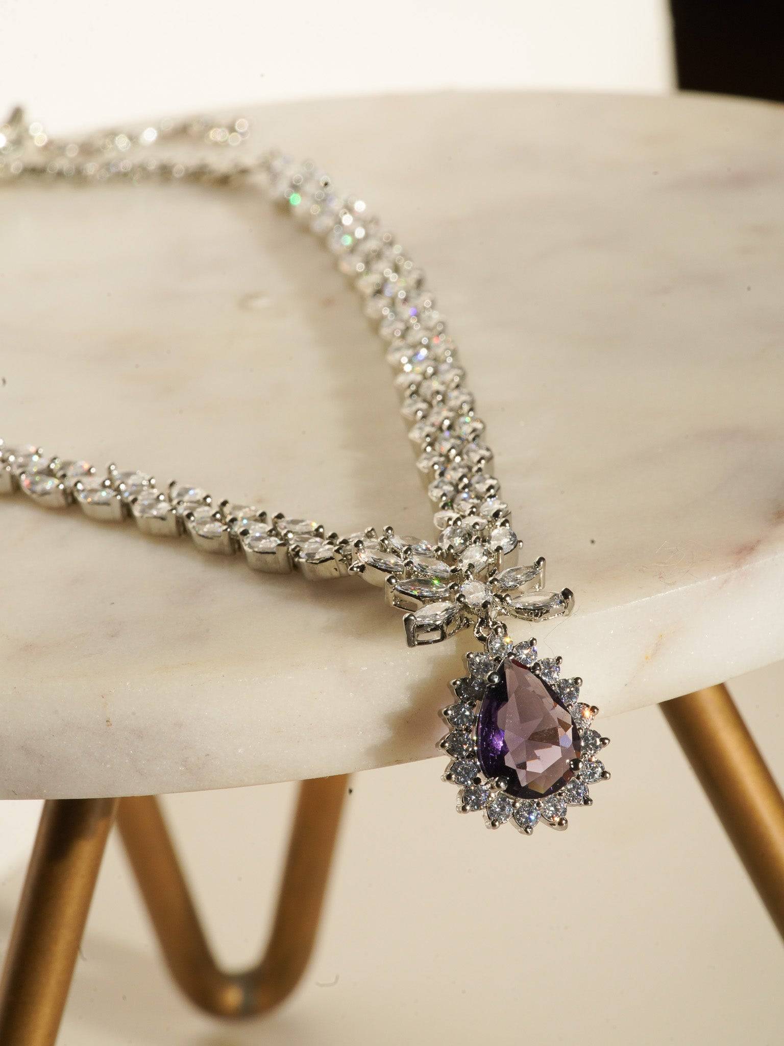 Lina Long Diamante Accent AD Necklace Set - Rhodium-plated with white AD stones, featuring intricate patterns and pendant-like centerpiece, available in silver & sapphire blue, silver & purple, and silver & citrine yellow, with matching dangling earrings.