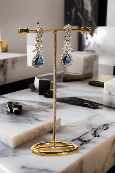 Lina Long Diamante Accent AD Necklace Set - Rhodium-plated with white AD stones, featuring intricate patterns and pendant-like centerpiece, available in silver & sapphire blue, silver & purple, and silver & citrine yellow, with matching dangling earrings.