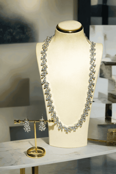 Lama Single Layer Long Diamante Accent AD Necklace Set in rhodium-plated silver or gold finish with intricate floral pattern and matching dangling earrings.