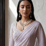 Close-up of the Inaury Saffina Set showcasing the brilliant craftsmanship of the rhodium-plated necklace, teardrop pearls, and matching dangling earrings.