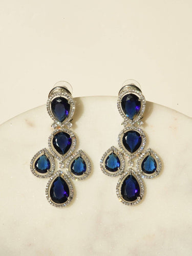 Niara Triple Layer Diamante Accent AD Necklace Set in gold or rhodium-plated silver finish with color options of silver & sapphire blue, silver & green, gold & green, and silver & ruby, featuring triple-layered chain links and matching statement earrings.