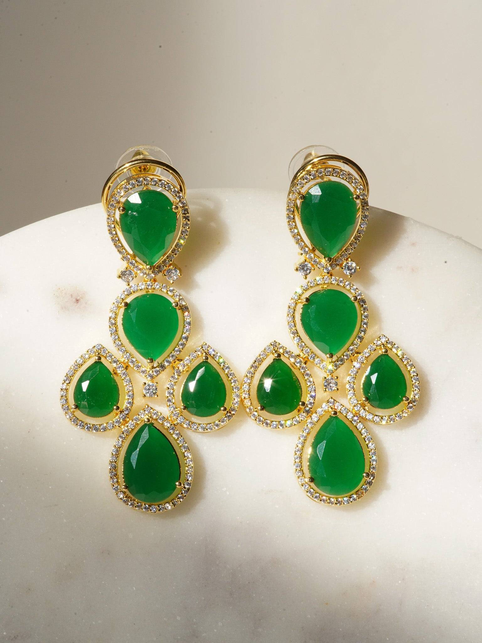 Niara Triple Layer Diamante Accent AD Necklace Set in gold or rhodium-plated silver finish with color options of silver & sapphire blue, silver & green, gold & green, and silver & ruby, featuring triple-layered chain links and matching statement earrings.