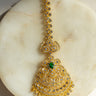 Gold and green maang tikka with American Diamond accents and teardrop dangles from Inaury.com