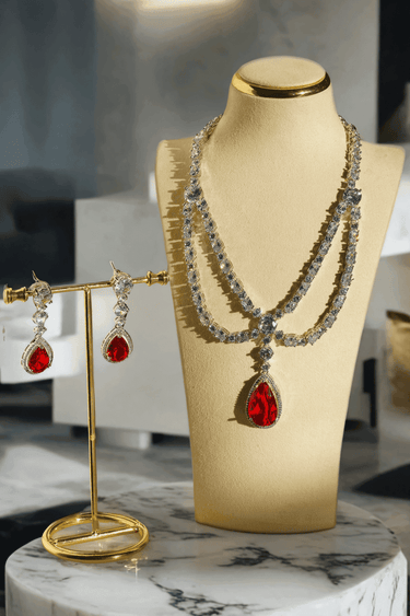 Nira Double Layered AD Necklace Set with criss-cross pattern, large teardrop pendant, and matching earrings in silver and mint green, silver and light pink, or silver and maroon.