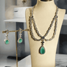 Nira Double Layered AD Necklace Set with criss-cross pattern, large teardrop pendant, and matching earrings in silver and mint green, silver and light pink, or silver and maroon.