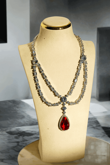 Nira Double Layered AD Necklace Set with criss-cross pattern, large teardrop pendant, and matching earrings in silver and mint green, silver and light pink, or silver and maroon.