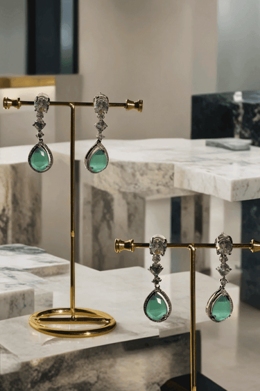 Nira Double Layered AD Necklace Set with criss-cross pattern, large teardrop pendant, and matching earrings in silver and mint green, silver and light pink, or silver and maroon.