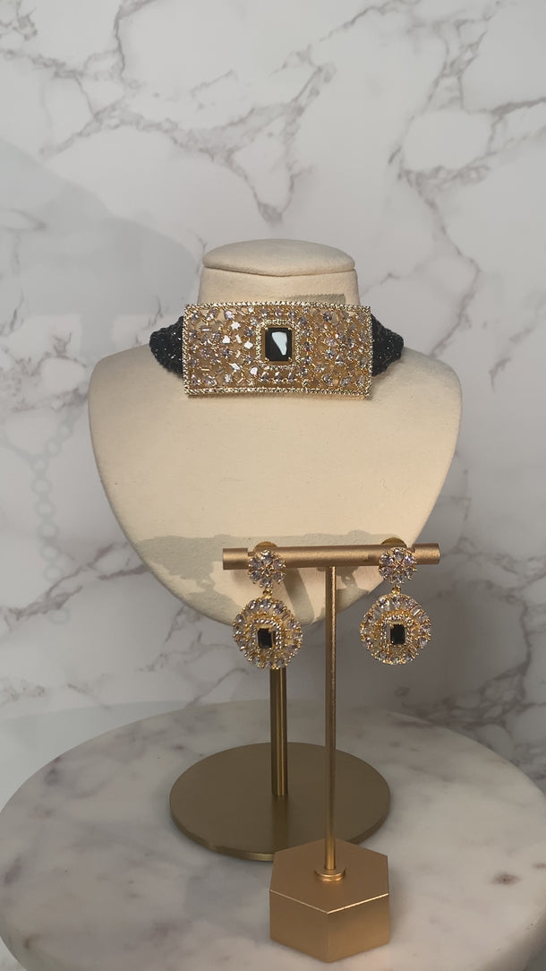 Luna Chic Choker Set in black with gold-plated pendant and matching earrings on marble stand, perfect for chic and formal styling.