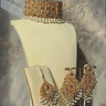 Esmeray Gold Choker Necklace Set with pearl drops and matching earrings and tikka, styled against a marble backdrop for bridal wear.