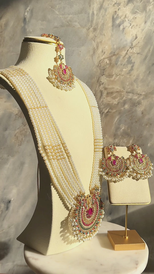 Side view of Inza Mala Necklace & Tikka Set featuring layered pearl strands and intricate ruby and gold detailing on a mannequin.