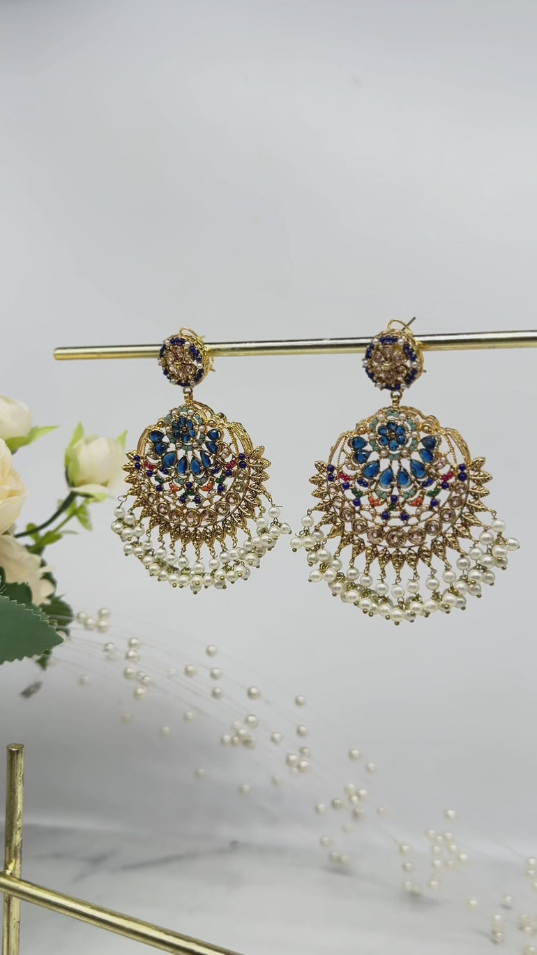 Blue and gold Inaya Earring & Maang Tikka Set - Statement | Chandbali with pearl drops, displayed on a gold stand for jewelry collection.