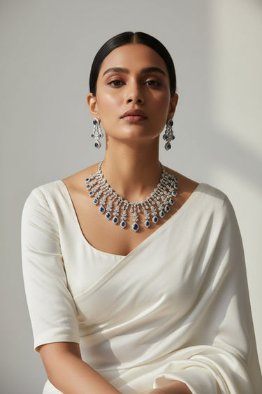 Raha Diamante classic necklace and earring set styled with white saree drape showing blue sapphire accents