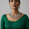 Raha Diamante Accent Classic Necklace Set with emerald green stones styled with green saree