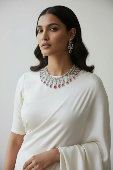 Side profile view of Raha Diamante necklace set with ruby pink stones styled with white saree