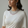 Angled view of Raha Diamante classic necklace and chandelier earrings with ruby pink accents on white saree