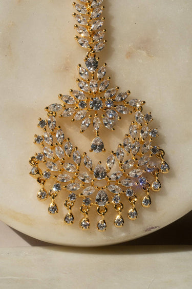Reema maang tikka in gold with CZ stones and tear-drop accents from Inaury