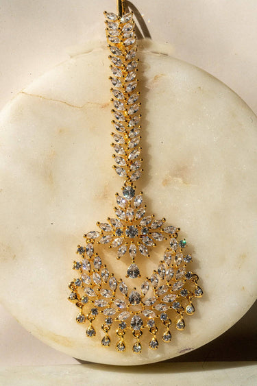 Reema maang tikka in gold with CZ stones and tear-drop accents from Inaury