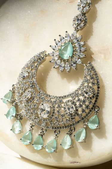 Rhodium-plated silver and mint green maang tikka with American Diamond stones in pink, ruby, mint green, and white from Inaury