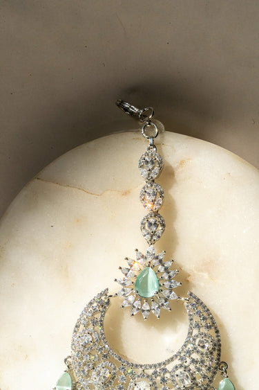 Rhodium-plated silver and mint green maang tikka with American Diamond stones in pink, ruby, mint green, and white from Inaury