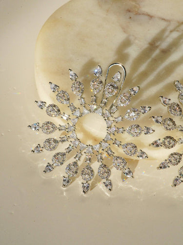 Starburst Statement Earrings with rhodium plating and pavé stones on a gold stand; 2.3-inch oversized studs with secure hook backs for elegance.