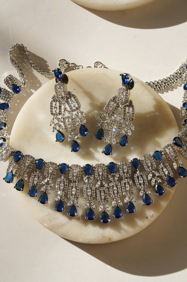 Full Aagya AD Necklace Set – Rhodium Plated in blue, including necklace and earrings with shimmering CZ and blue stones.