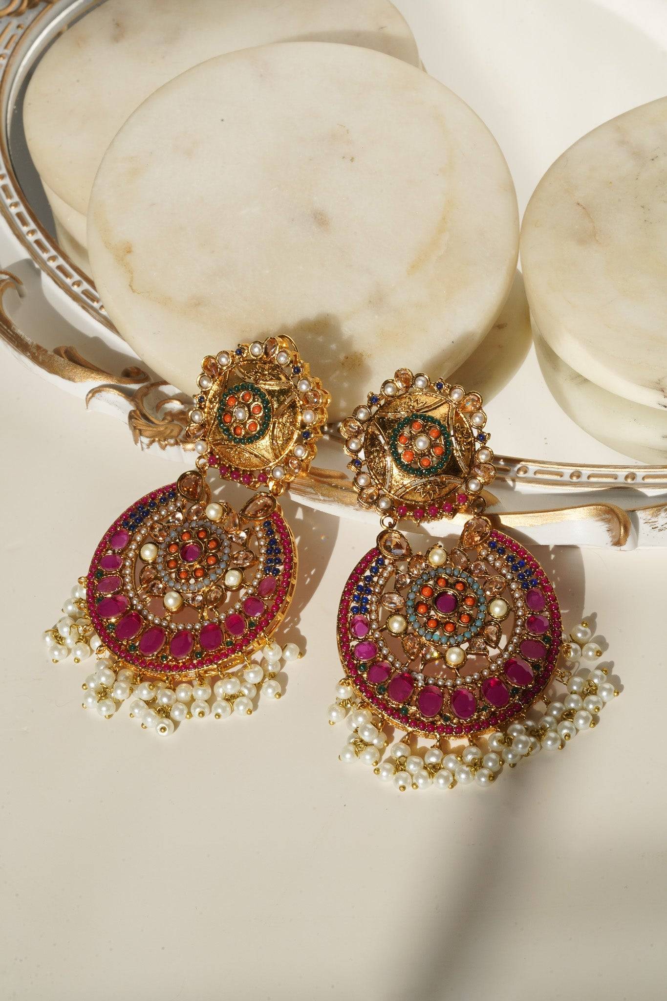 Front view of Adiva Statement Earrings with intricate gold, red, and green stonework and pearl fringe.