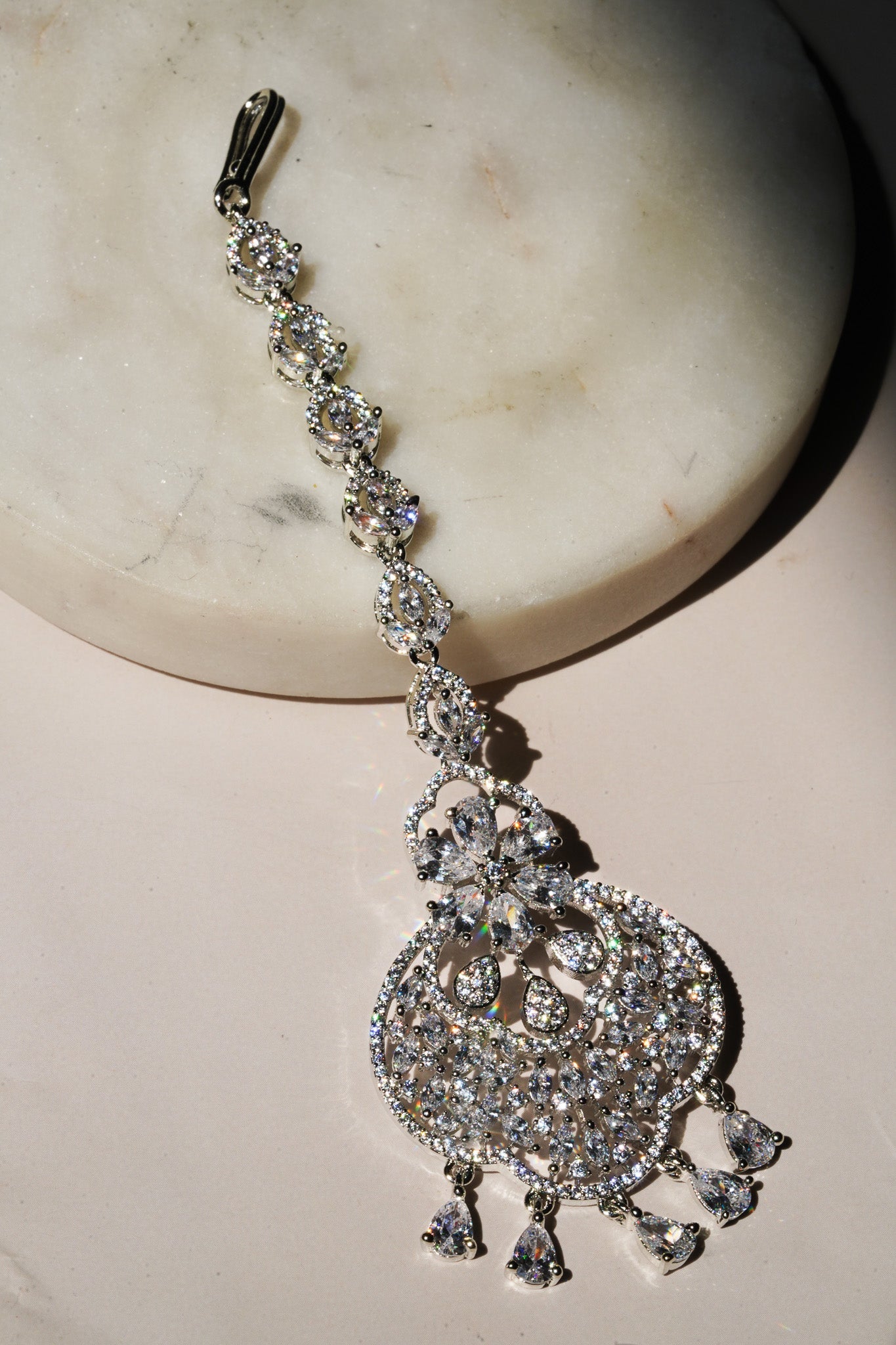 Rhodium-plated floral maang tikka with AD stones in a silver and white from Inaury