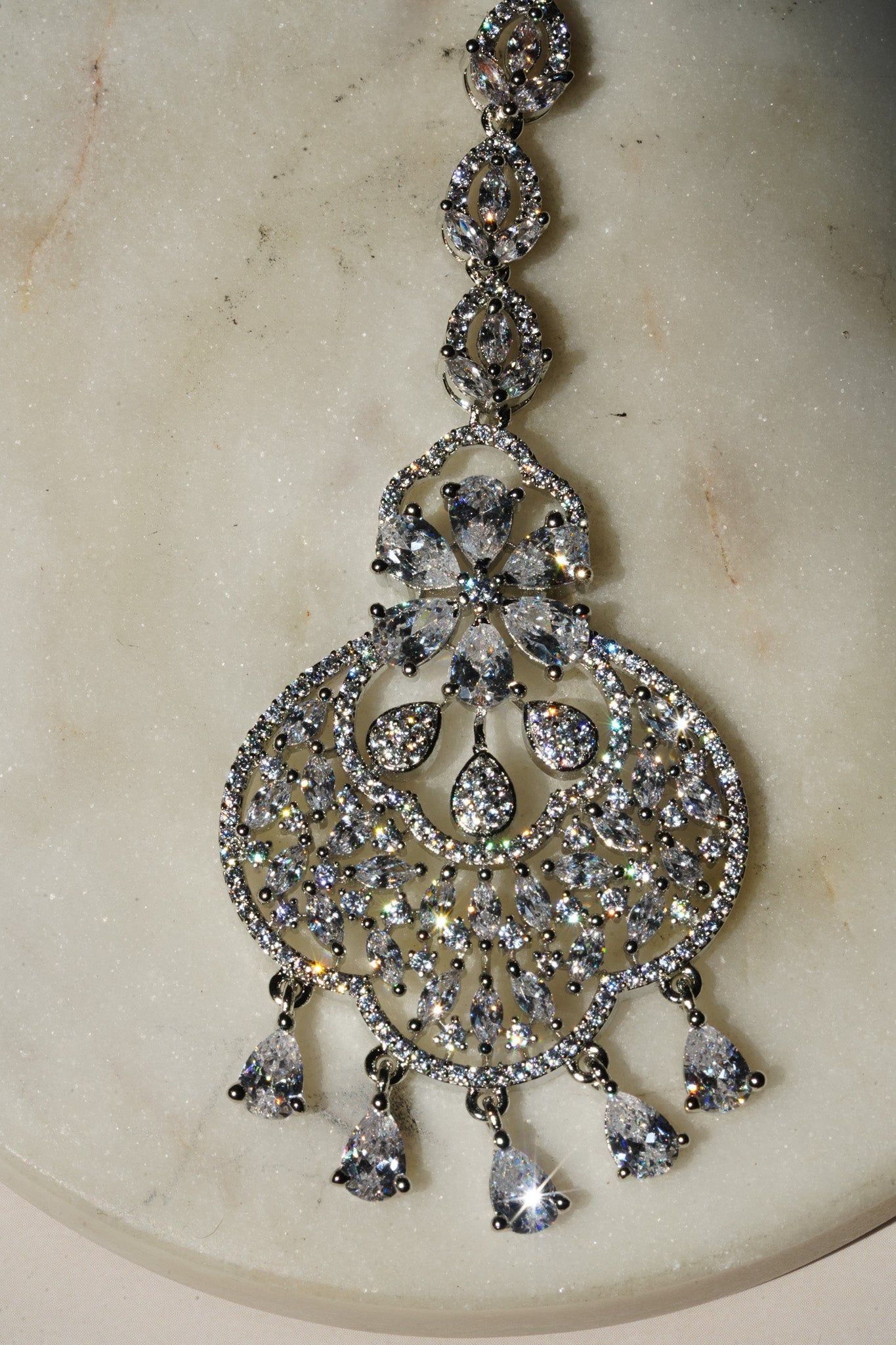 Rhodium-plated floral maang tikka with AD stones in a silver and white from Inaury