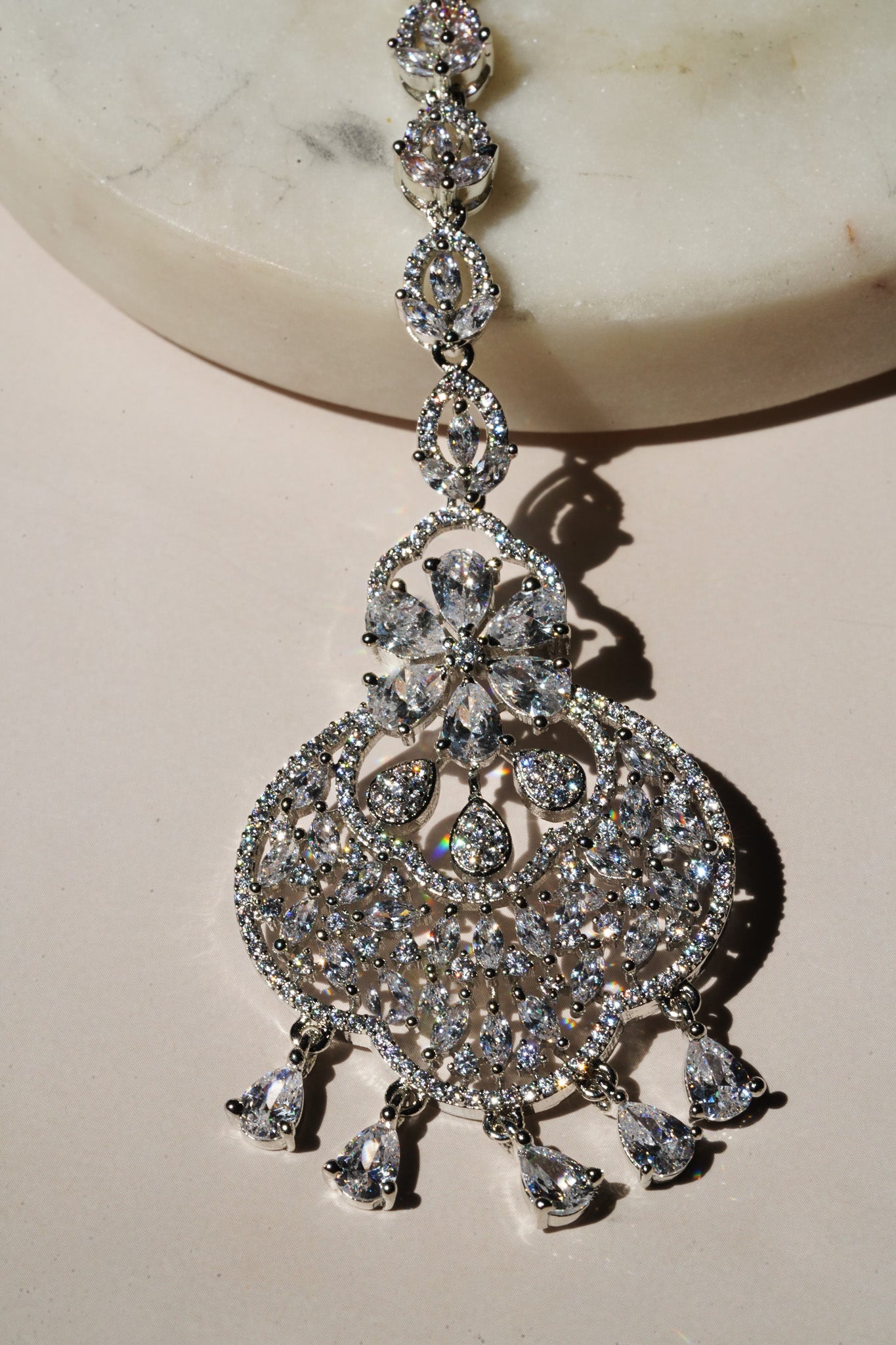 Rhodium-plated floral maang tikka with AD stones in a silver and white from Inaury