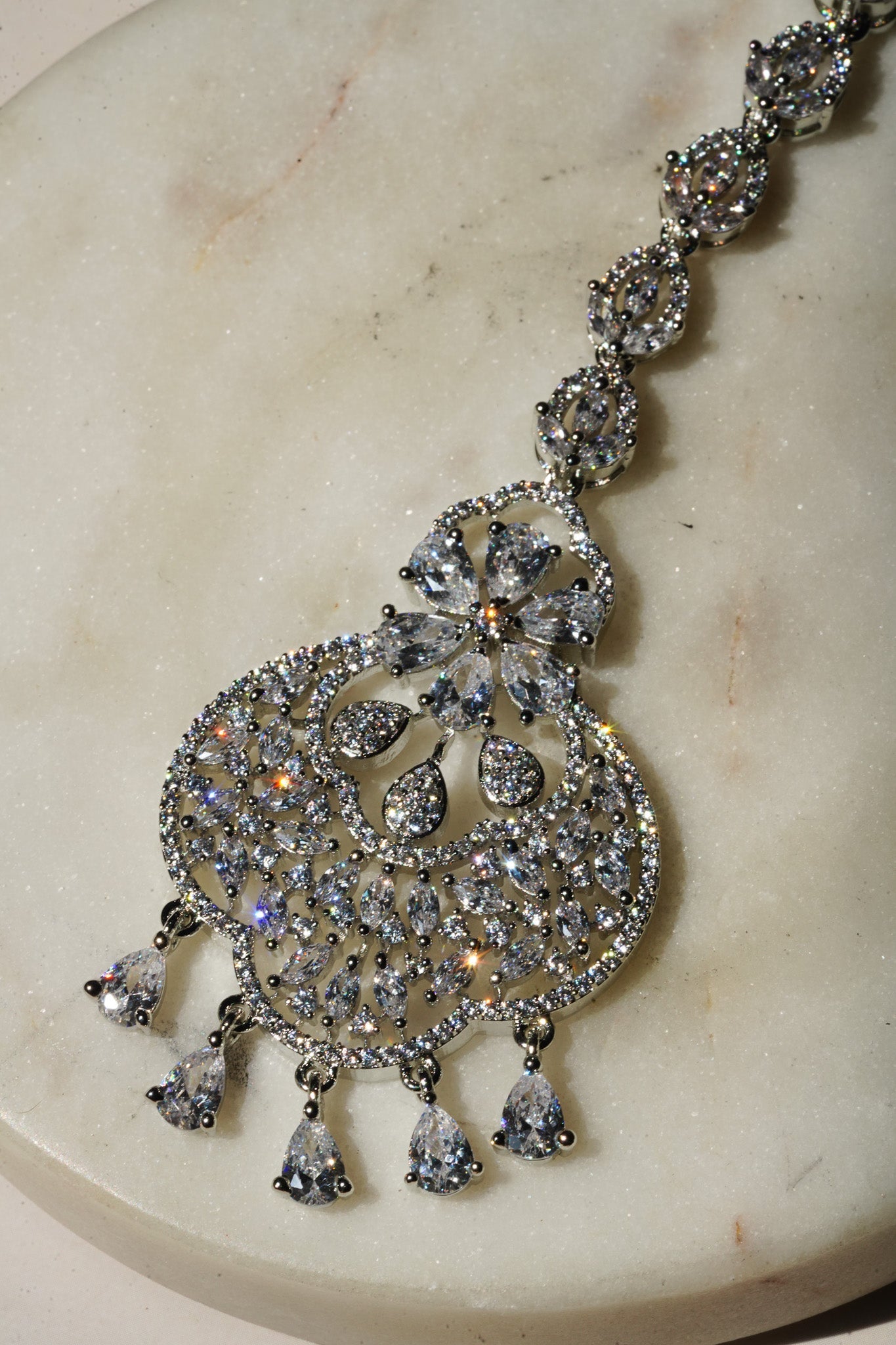 Rhodium-plated floral maang tikka with AD stones in a silver and white from Inaury