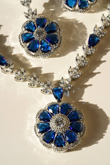 Close-up of Chahat Necklace Set - Rhodium Floral AD in blue. Features intricate floral pendant with sparkling AD stones.