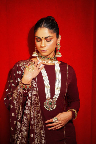 Model styled in Chaya Navratan choker necklace and jhumka earrings, paired with maroon ethnic attire for a regal wedding look.