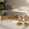 Chaya Navratan choker necklace with green stones and pearl fringe, styled for traditional South Asian weddings and events.