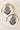 Pair of Esmeray Silver Earrings with black bead fringe and crystal detailing, styled on marble for product showcase.