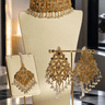 Esmeray Gold Necklace Set - Choker & Maang Tikka with intricate detailing and pearl accents, ideal for festive and wedding occasions.