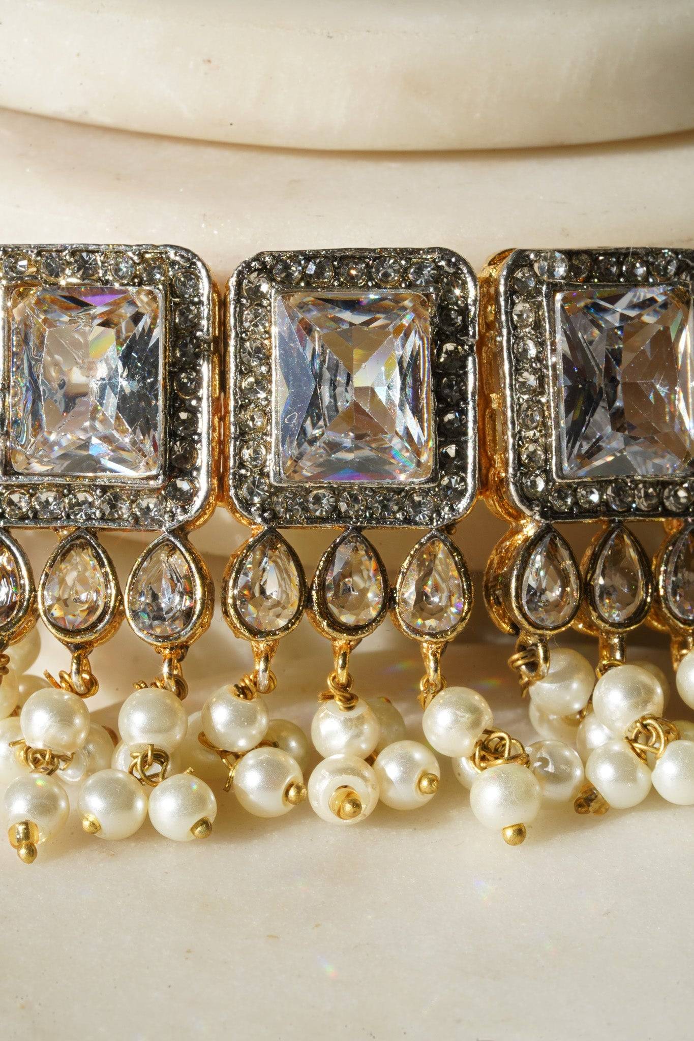 Jahanara Gold Plated Choker Necklace Set - Artisan crafted with cushion cut center stones, zircon rims, teardrop accents, 1.5" earrings, and a charming maang tikka.